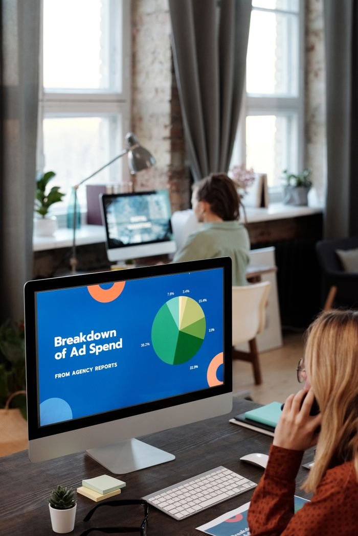 Bright office setting with computers displaying data, illustrating productivity in a workspace.
